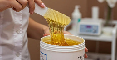 Esthetician testing wax temperature for leg waxing