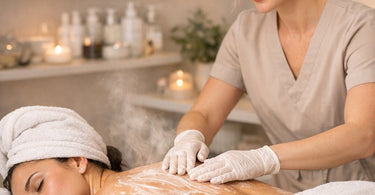 A relaxing spa treatment where an esthetician performs a back facial on a client, with organized product pairings nearby.