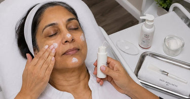 A spa professional applying sunscreen to a smiling client's face as a finishing touch to a facial service, promoting skin protection and wellness.