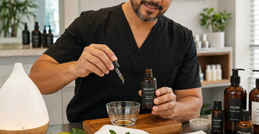 A glass bottle of bright golden bergamot essential oil on a white surface, surrounded by fresh bergamot fruit and white blossoms, representing professional aromatherapy for spas and salons