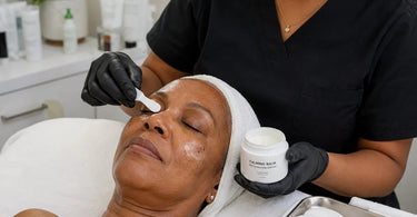 A skincare professional applying a soothing calming balm to a client's face after professional facial extractions in a serene spa setting