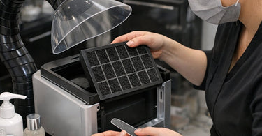 Close up of a clean charcoal filter being held by a salon professional, symbolizing fresh air and purified environment in a beauty workspace.