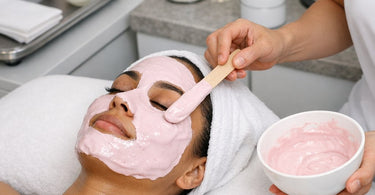 Professional applying green alginate peel-off mask with spatula to client in spa, highlighting the benefits of using alginate masks over sheet masks for lifting and hydration.
