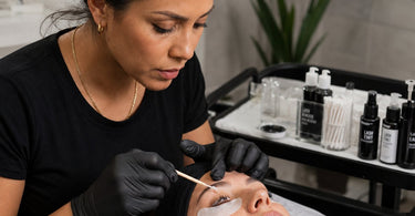 A close-up image showing a professional applying antioxidant-infused lash tint to a client's lashes, promoting lash health and beauty.