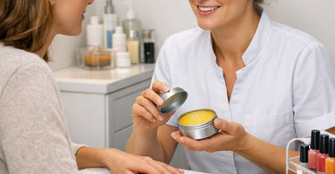 Close up of a professional nail technician applying carnauba wax buffer to a client's fingernail for a high gloss shine finish at a salon spa.