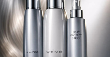 A salon retail display featuring a bundled set of professional shampoo, conditioner, and heat protectant spray with luxe accessories