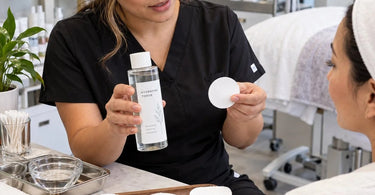 Professional cotton rounds for toner application arranged on a spa treatment tray with skincare products