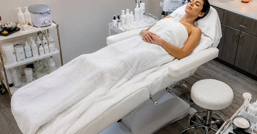 A comfortable and adjustable esthetician chair being used during a professional facial service, highlighting ergonomic design and client comfort.
