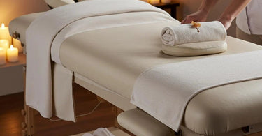 A comfortable and well-padded massage table set up in a serene spa environment