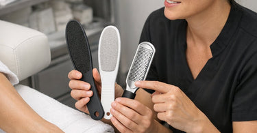 An array of professional pedicure files including metal, crystal, and disposable boards laid out on a spa towel for salon use.