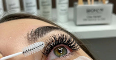 Close-up of beautifully applied lash extensions with a brush for aftercare