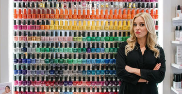 A beautifully organized nail polish wall rack in a professional salon setting