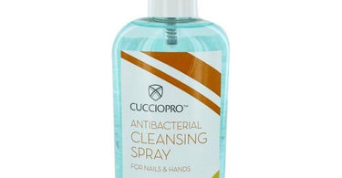 Cuccio Pro Antibacterial Cleansing Spray bottle with citrus fruits, showcasing salon hygiene product for nail professionals