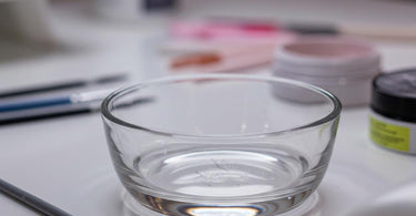 A Dappen Dish, a small glass container used in spa and salon services for holding liquids, wax, or powders.