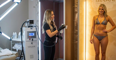 Woman receiving a professional spray tan in a salon setting