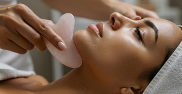 Gua Sha tool on a spa towel with skincare products in the background