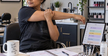 Beauty professional taking a short stretch break between clients in a spa treatment room