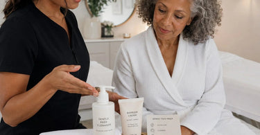 A professional spray tan technician preparing a client for a session, highlighting key prep steps like exfoliation and proper attire in a bright, welcoming salon.