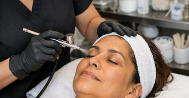 Close up of professional airbrush makeup needle being cleaned and inspected with tools on a white surface
