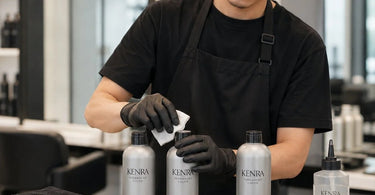 Clean hair color bottle cap and brush on a salon counter.