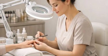 A nail technician and lash artist demonstrating proper ergonomic posture at their workstations, with good lighting and tools within reach.