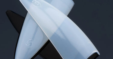 Box of Lamour Natural Stiletto Nail Tips showcasing the ultra slender and pointy shape on a salon table
