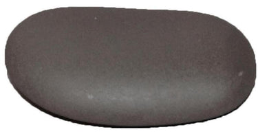 A large, smooth, oval basalt sacral/belly stone resting on a soft white towel, ready for a warm, relaxing hot stone massage therapy session.