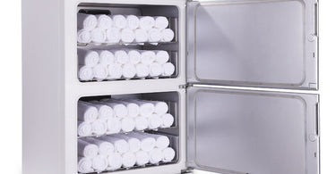 Open hot towel cabinet filled with neatly stacked warm towels