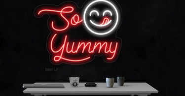 The 'So Yummy' LED Flex Neon Sign glowing in a modern spa or salon setting, showcasing its vibrant light and clear acrylic backing.