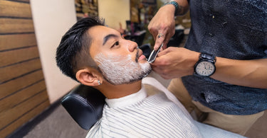 Male client getting a straight razor shave in a barber shop