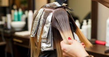 Professional stylist applying Hi Lift Hair Color in a salon setting