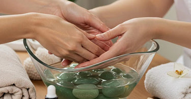 Various healing crystals arranged around spa products on a massage table