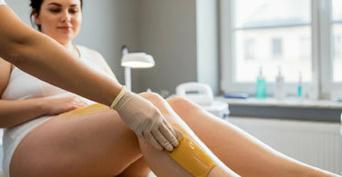 Plus-sized woman getting her legs waxed at a spa