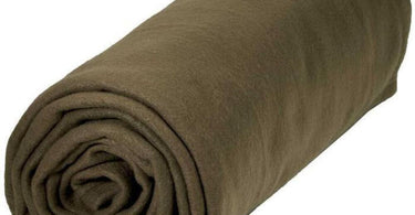 A plush chocolate brown polar fleece blanket elegantly draped over a massage table in a spa setting.