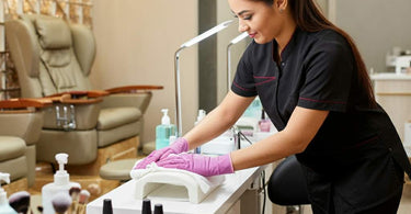 Salon technician cleaning a station with medical-grade disinfectants