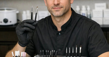 Precision brushes and applicators for professional bottom lash tinting arranged on a white towel