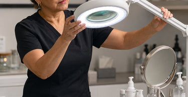 Professional magnifying mirror on stand with LED lights for detailed aesthetic work in a spa or salon