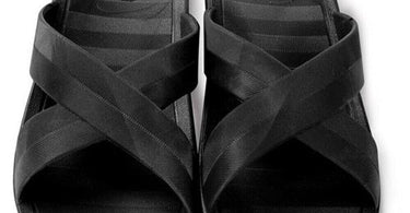 Sposh Cross Strap Sandal in Black, showing the secure cross-strap design and anti-slip sole, placed on a spa towel.