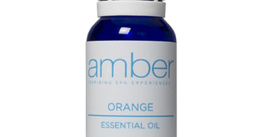 Amber Products Sweet Orange Essential Oil bottle with fresh oranges
