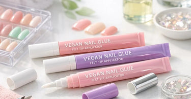 Close-up of a professional nail technician using a felt-tip applicator bottle of vegan nail glue for precise nail tip adhesion