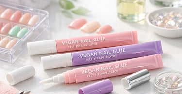 Close-up of a professional nail technician using a felt-tip applicator bottle of vegan nail glue for precise nail tip adhesion