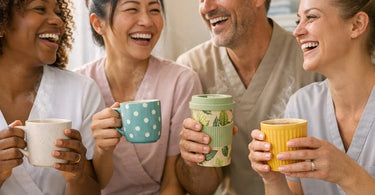 A close-up image of various coffee cups and mugs on a spa tray next to rolled towels and a small plant, symbolizing the connection between client mood and service personalization in a spa setting.