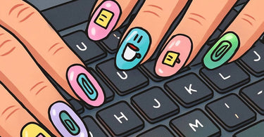 A woman's hands with a chic, short manicure typing on a laptop keyboard, showcasing office-appropriate nail art.
