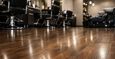 A stylish and durable luxury vinyl plank floor in a modern salon, featuring a massage table and salon chair, representing the ultimate guide to salon flooring that won't buckle.