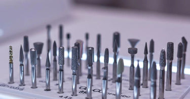 Various types of nail drill bits displayed on a table