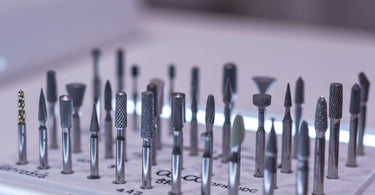 Various types of nail drill bits displayed on a table