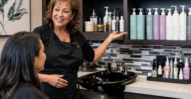 An organized salon backbar with neatly labeled shampoo bottles and supplies creating a professional and welcoming atmosphere for clients.