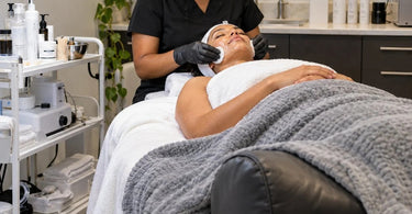 Professional spa facial room showing a treatment bolster used for client positioning during a high-volume service day