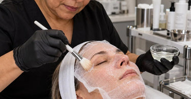 Professional facial gauze positioned over a client's face during a spa skincare treatment, demonstrating proper gauze placement for facial mask product application