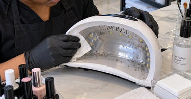 Professional UV and LED nail lamp at a clean salon manicure station showing why lint and filing dust buildup should be removed regularly